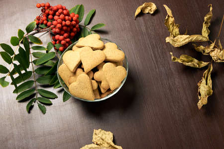 Autumn still life. Heart cookie. Rowan branch. Yellow leaves.の写真素材
