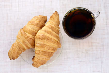 Delicious dessert. Fresh croissant. Cup black tea.の写真素材