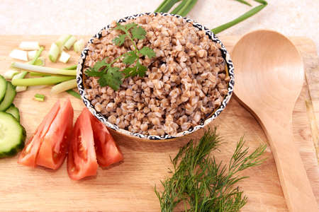Cooked buckwheat. Wooden spoon. Vegetable salad.の写真素材