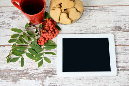White tablet. Rowan branch. Red circle. Gingerbread Cookie.の写真素材