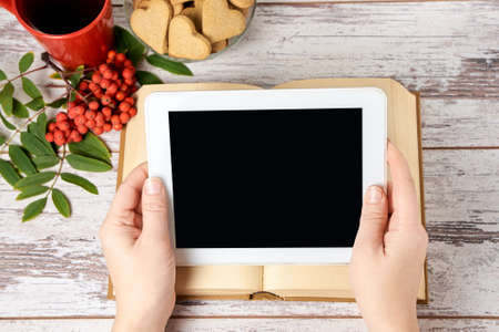 Modern tablet. Old book. Gingerbread Cookie. Rowan branch. の写真素材