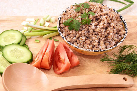 Cooked buckwheat. Vegetable salad. Wooden spoon.の写真素材