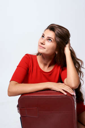 Pensive brunette. Journey. Girl with a suitcase.の写真素材