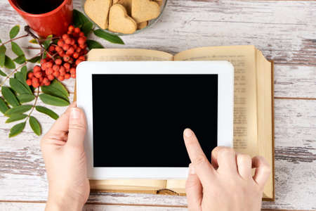 Modern tablet. Old book. Rowan branch. Gingerbread Cookie.の写真素材