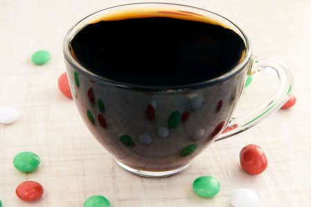 Small multi-colored sweets. Hot black tea. Reflection.の写真素材