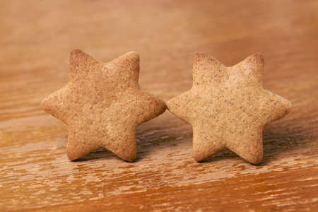 Two stars. Gingerbread Cookie. Brown background.の写真素材