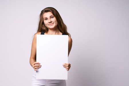 Girl with poster. White background. Template.の写真素材