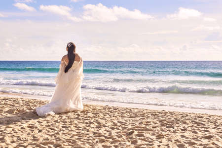 Bride on beach. White dress. Blue sea.の写真素材
