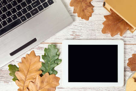 Autumn leaves. Modern tablet. Gray notebook.の写真素材