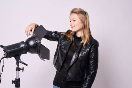 Girl Photographer. Spotlights in studio. White background.の写真素材