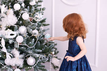 Little girl. Bright interior. Blue dress. Christmas decorations.の写真素材