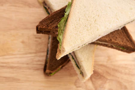Sandwich with ham. White and black bread. Green salad.の写真素材