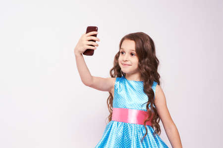 Pretty Girl. Photo on phone. Lush blue dress.の写真素材