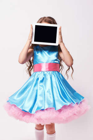 Little girl. Fluffy dress, Modern tablet.の写真素材