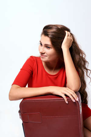 Pensive brunette. Journey. Girl with a suitcase.の写真素材