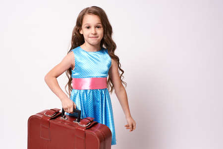 Waiting for trip. Little cute girl. Large suitcase.の写真素材