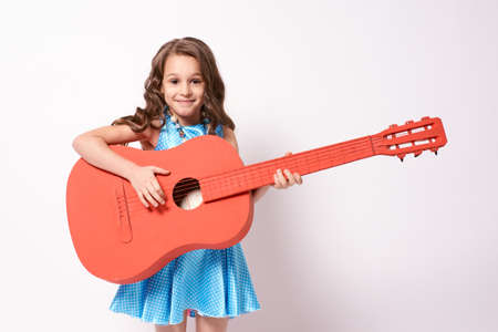 Little girl. Red Guitar. White background.の写真素材