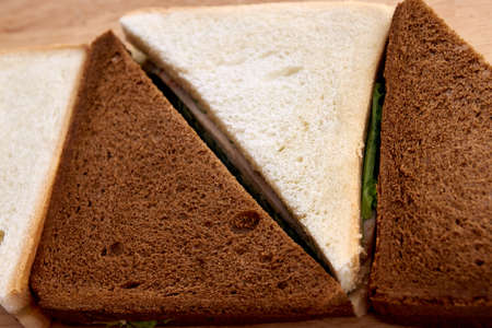 White and black bread. Sandwich with ham. Green salad.の写真素材