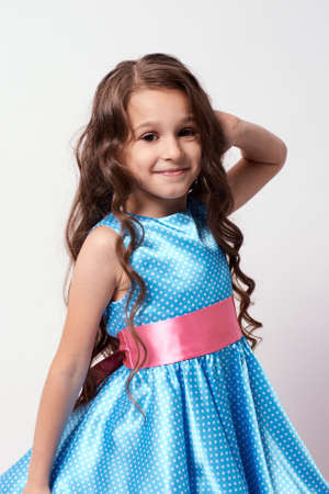 Beautiful little girl. White background. Blue dress.の写真素材
