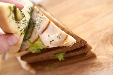 Sandwich with ham. White and black bread. Light background.の写真素材