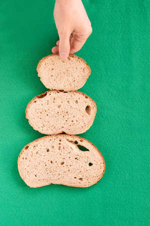 Three slices  bread. Unusual tree. Green background.の写真素材