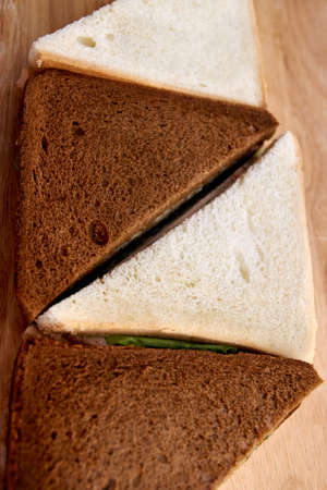 White and black bread. Green salad. Sandwich with ham.の写真素材