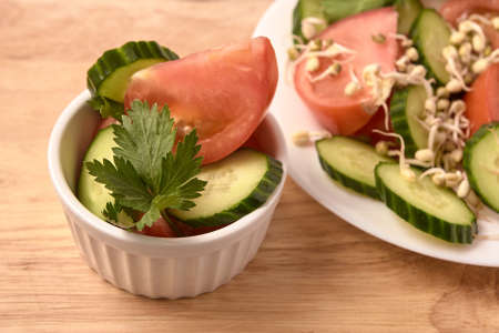 Tomato and cucumber. White plate. Sprouted beans. Fresh salad.の写真素材
