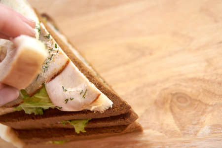 Sandwich with ham. White and black bread. Light background.の写真素材