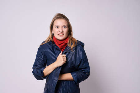 Chills. Warm clothes. Young girl. White background.の写真素材