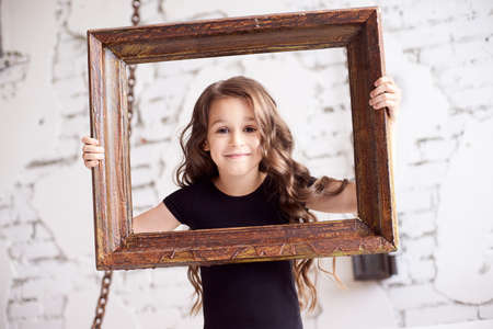 Portrait girl. Wooden frame. Light background.の写真素材