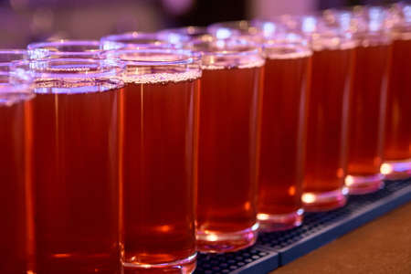 Red drink. Same glasses. Dark background.の写真素材