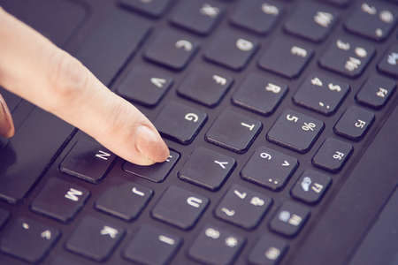 Finger. Pressing key. Notebook button.の写真素材