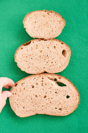 Unusual Christmas tree. Green background. Pieces bread.の写真素材