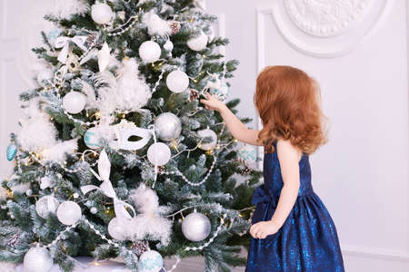 Little girl. White background. Blue dress. Christmas decorations.の写真素材
