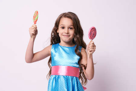 Little girl. Delicious sweetness. Multicolored lollipops.の写真素材