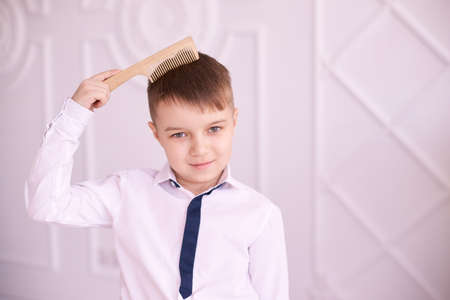 Little boy. Wooden comb. Bright interior. Horizontal.の写真素材