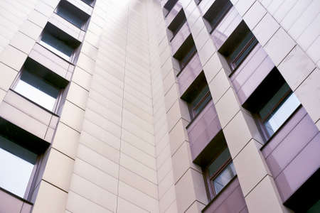 Modern high rise building. Light tiles. Many windows.