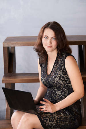 Black notebook. Girl works. Brown background.