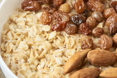 Oatmeal with almonds and raisins. Useful breakfast.の写真素材