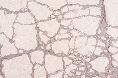 Ruined light gray asphalt. Many large cracks.