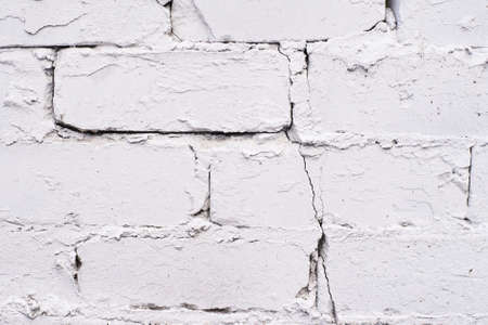 White coating. Old brickwork. Uneven surface.