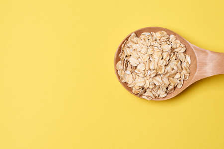 Muesli for breakfast. Healthy food. Yellow background. Wooden spoon.の写真素材