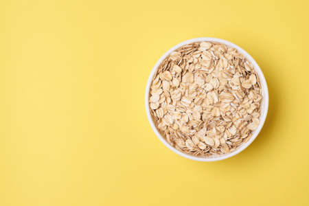 Muesli for breakfast. Healthy food. Yellow background. Many flakes.の写真素材