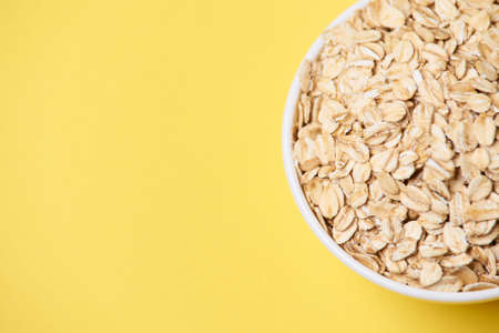 Healthy food. Muesli for breakfast. White bowl. Yellow background.の写真素材