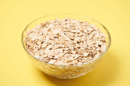 Healthy food. Muesli for breakfast. Yellow background. Bowl with flakes.の写真素材
