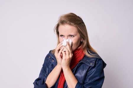 Young girl with cold. Bad feeling. Light background.の写真素材
