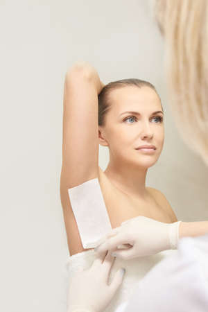 Home hair removal epilation with girl. Female depilation. No pain tool waxing, or sugaring.の写真素材