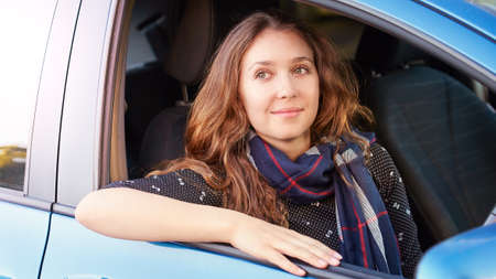 Girl seat at car. Passenger in blue wheel.の写真素材