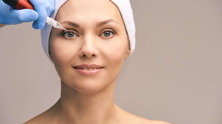 Permanant makeup tattoo. Woman face skin care. Cosmetologist female mikrobleyding.の写真素材