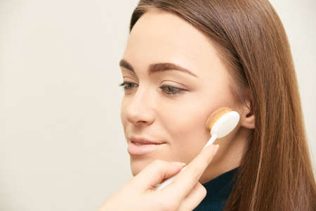 Makeup professional artist apply face mascara. Woman beauty model. Nature nude look. Contour foundation.の写真素材